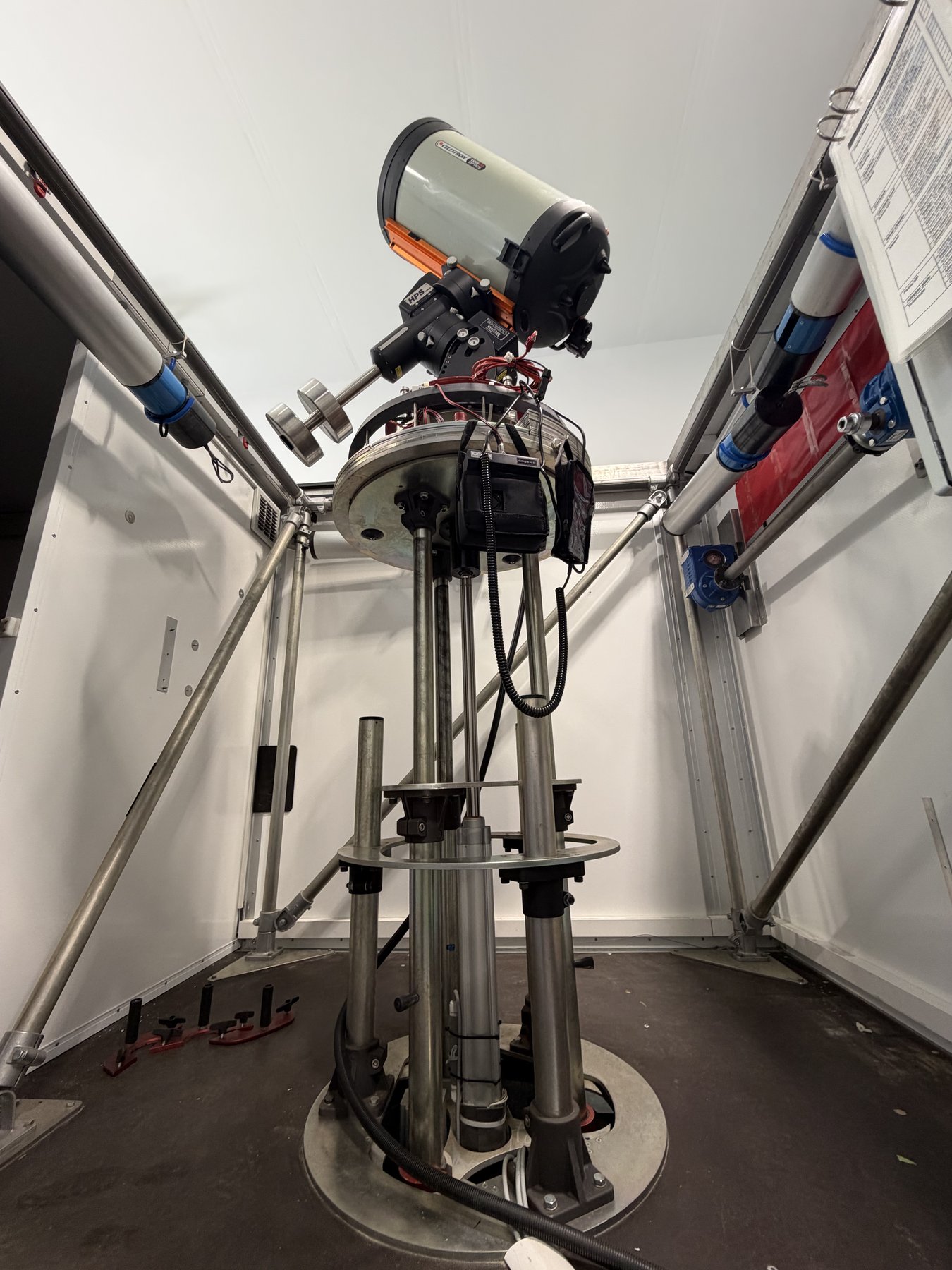 The full telescopic pier inside the observatory cabin, floor-anchored with the mounted telescope above