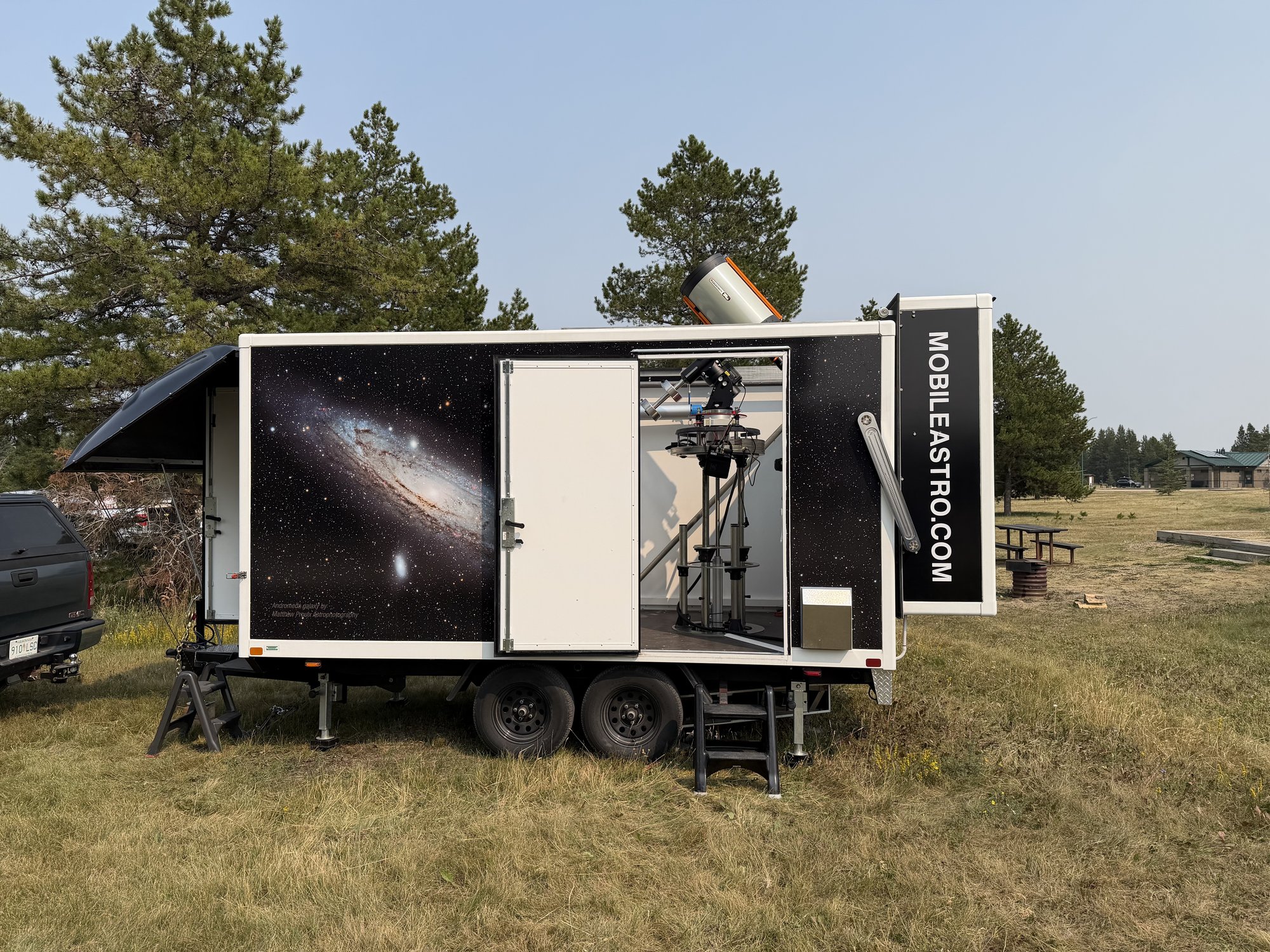 The trailer deployed in observation mode — roof tilted back, telescope raised above the roofline